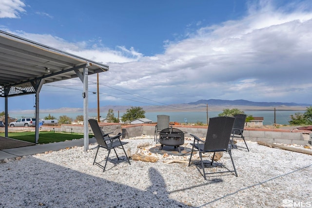 view of patio with a fire pit and a water and mountain view