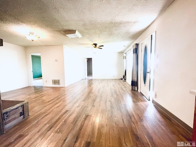 unfurnished living room featuring a textured ceiling, wood-type flooring, and ceiling fan