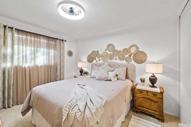 bedroom featuring a textured ceiling and light colored carpet