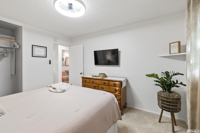 bedroom with a textured ceiling and light carpet