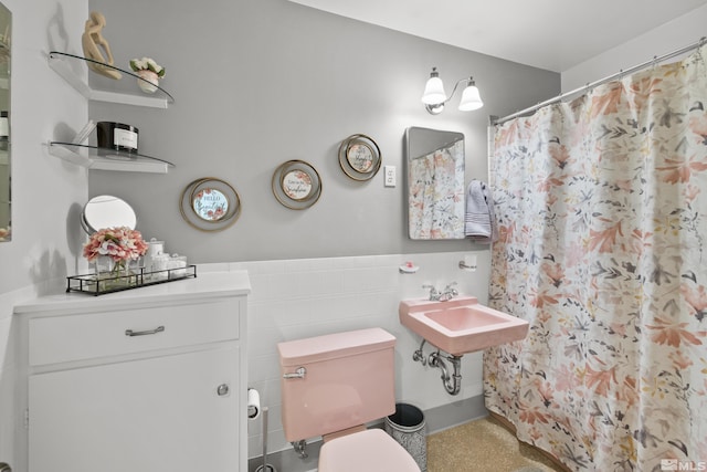 bathroom with sink, tile walls, and toilet