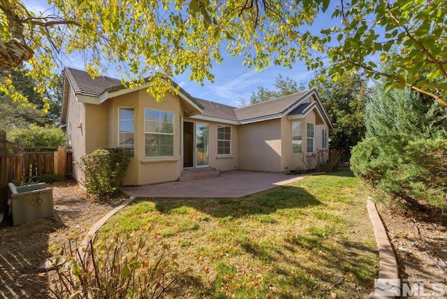 back of property featuring a lawn and a patio area