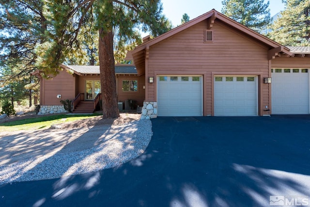 view of front of home featuring a garage and central air condition unit