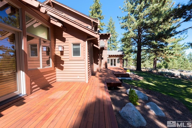 wooden terrace with a lawn