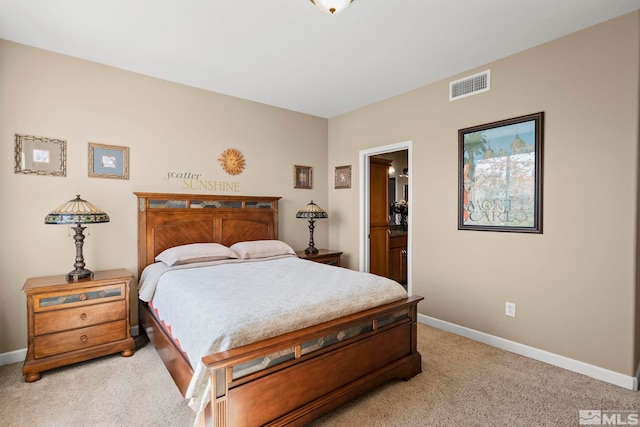 bedroom with light carpet and ensuite bathroom