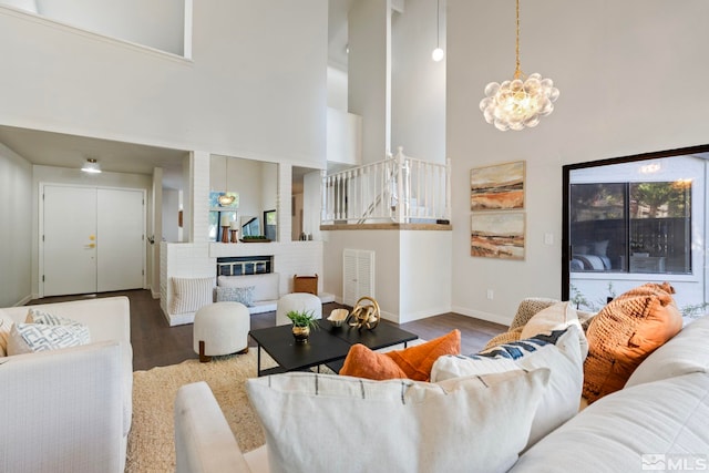 living room featuring a notable chandelier, a high ceiling, and dark hardwood / wood-style flooring