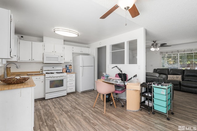 kitchen with white appliances, white cabinets, light wood-type flooring, and ceiling fan