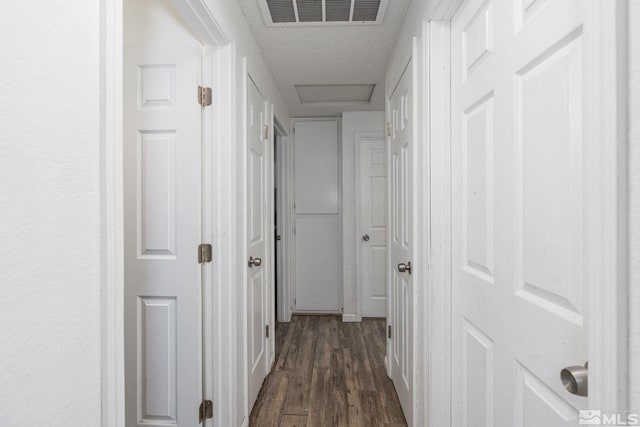 hallway with dark hardwood / wood-style flooring and a textured ceiling