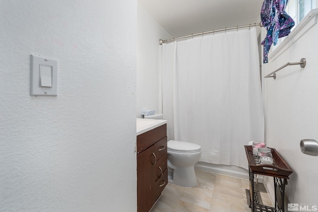 bathroom with vanity, toilet, and curtained shower