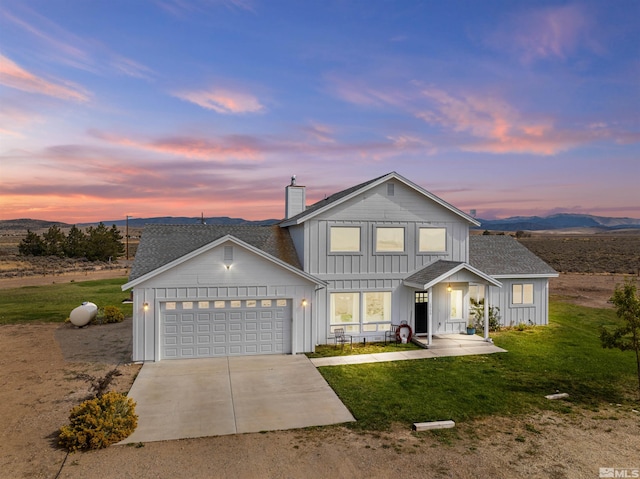 view of front facade featuring a mountain view, a garage, and a yard