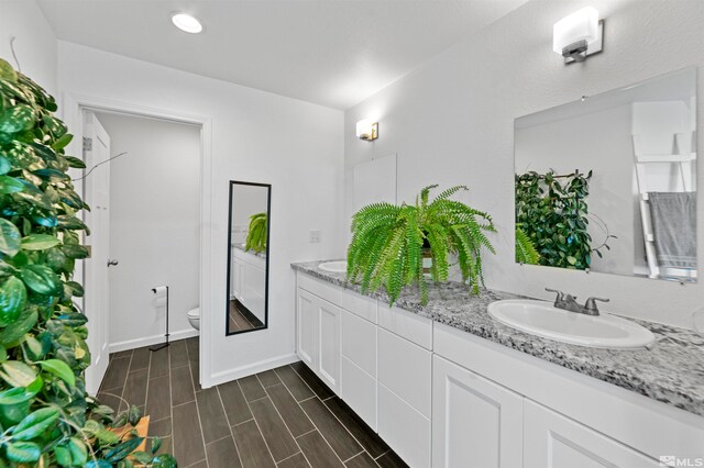 bathroom featuring wood-type flooring, vanity, and toilet