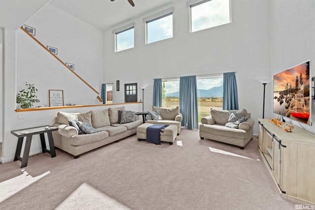 living room with ceiling fan, a wealth of natural light, and light colored carpet