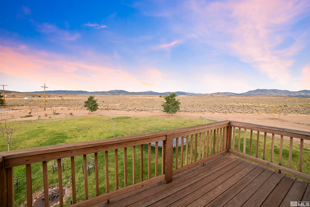 deck at dusk with a rural view and a mountain view