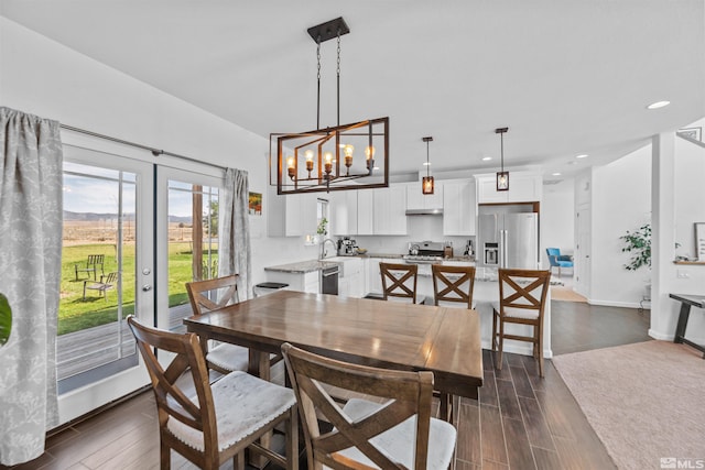 dining area featuring french doors, an inviting chandelier, and dark hardwood / wood-style floors