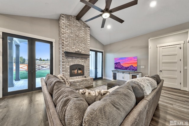 living room with ceiling fan, vaulted ceiling with beams, french doors, a fireplace, and hardwood / wood-style floors