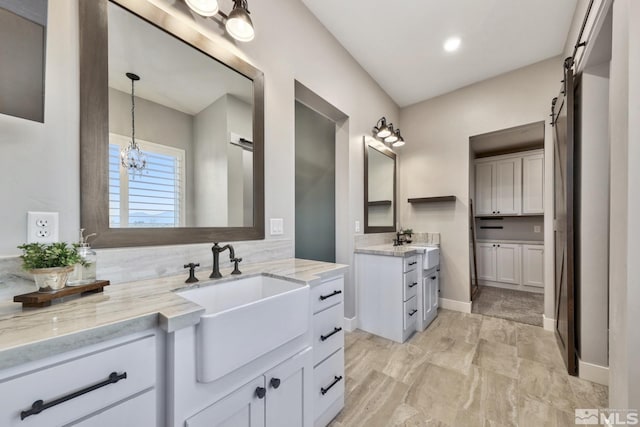 bathroom with tasteful backsplash, a notable chandelier, and vanity