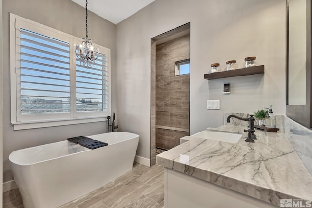 bathroom with plenty of natural light, a notable chandelier, vanity, and independent shower and bath