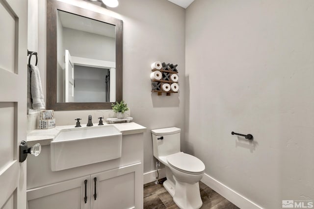 bathroom featuring hardwood / wood-style floors, vanity, and toilet