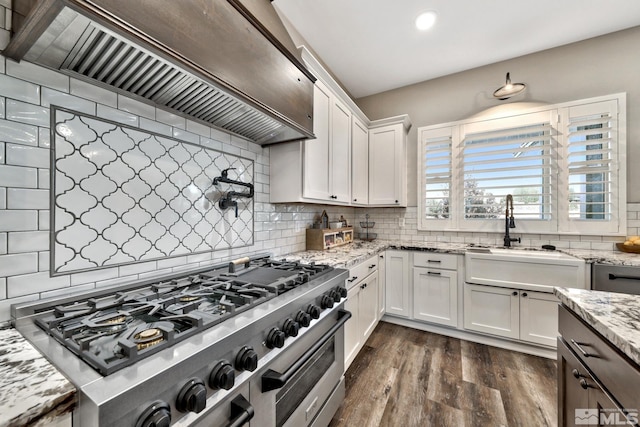 kitchen featuring custom exhaust hood, high end range, dark wood-type flooring, white cabinetry, and decorative backsplash