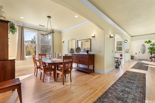 dining space featuring light wood-type flooring and crown molding