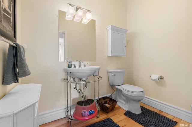 bathroom featuring hardwood / wood-style flooring, sink, and toilet