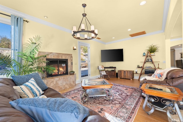 living room featuring a notable chandelier, light hardwood / wood-style flooring, a premium fireplace, and crown molding