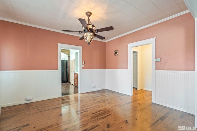 empty room featuring ornamental molding, hardwood / wood-style floors, and ceiling fan