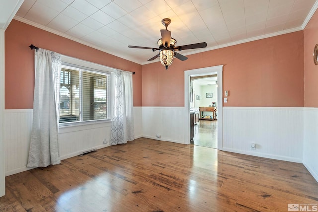 unfurnished room featuring wood-type flooring, ornamental molding, and ceiling fan