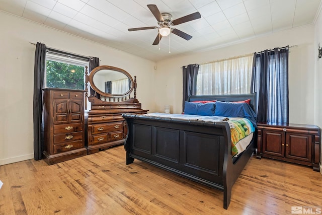 bedroom featuring ceiling fan, ornamental molding, and light hardwood / wood-style floors