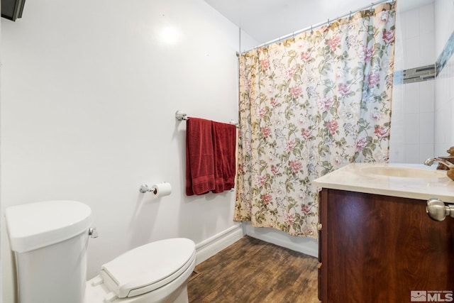 full bathroom with wood-type flooring, shower / bath combo with shower curtain, vanity, and toilet