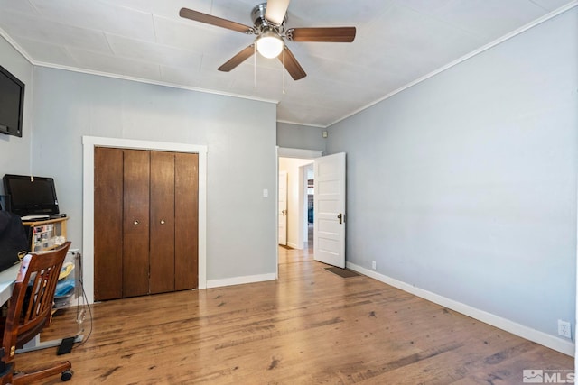 bedroom with ornamental molding, light wood-type flooring, ceiling fan, and a closet