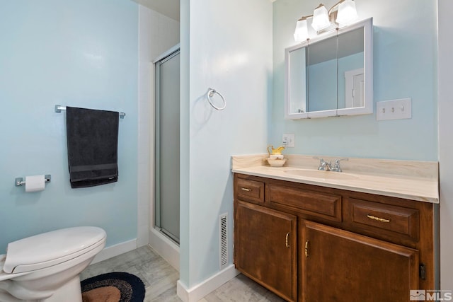 bathroom with vanity, toilet, and an enclosed shower