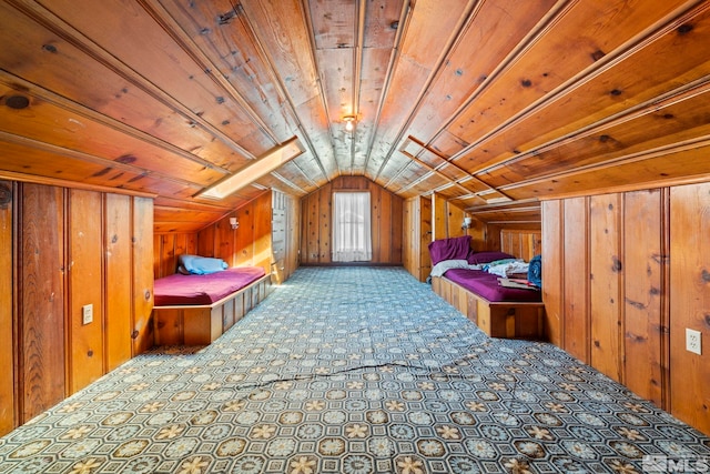 unfurnished bedroom with lofted ceiling with skylight and wood walls