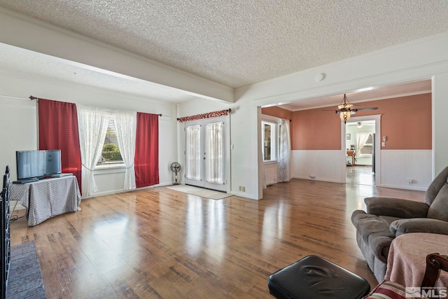 living room with ceiling fan, a textured ceiling, and hardwood / wood-style floors