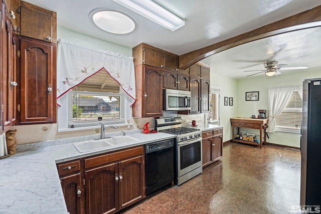 kitchen featuring decorative backsplash, appliances with stainless steel finishes, sink, and ceiling fan