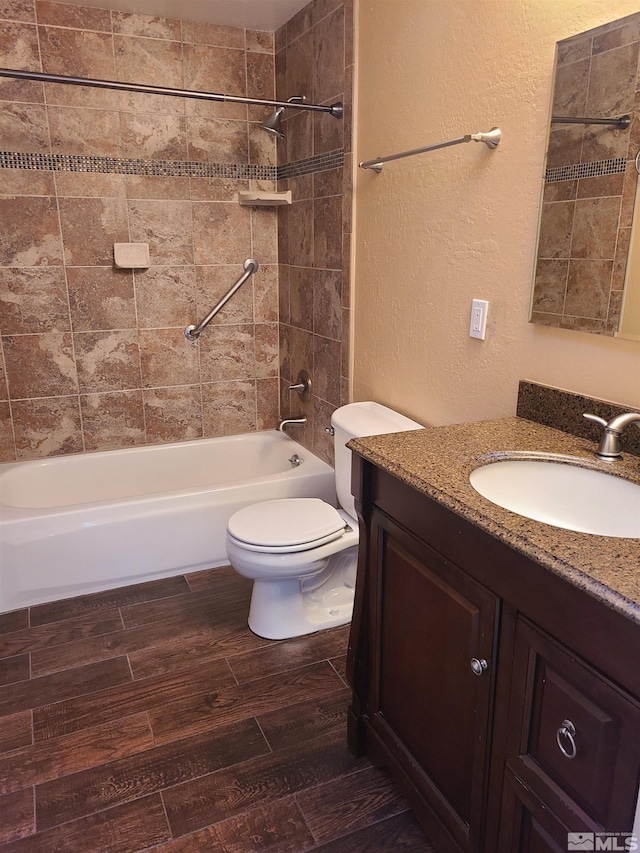 full bathroom with tiled shower / bath combo, hardwood / wood-style flooring, vanity, and toilet