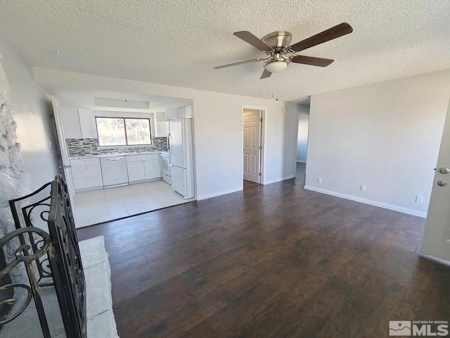 unfurnished living room featuring hardwood / wood-style flooring and a textured ceiling