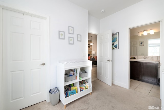 hall with light colored carpet and sink