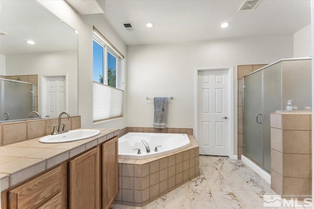 bathroom featuring vanity and shower with separate bathtub