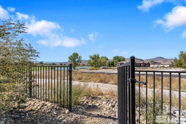 view of gate featuring a water and mountain view