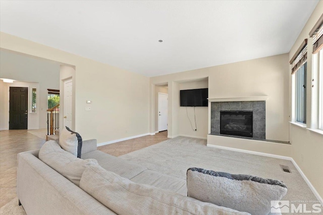 living room featuring light colored carpet and a tiled fireplace