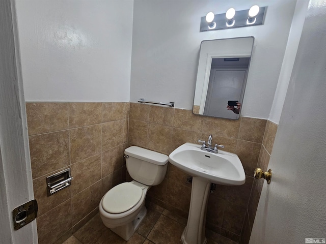 bathroom with tile walls, tile patterned flooring, and toilet