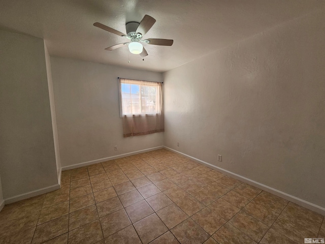 tiled spare room featuring ceiling fan