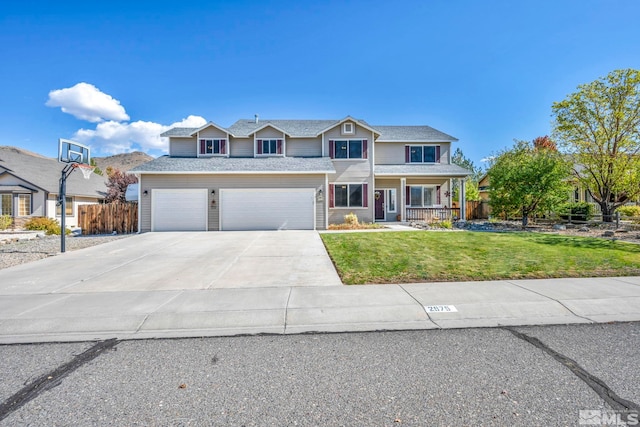 traditional home featuring concrete driveway, an attached garage, a front yard, fence, and covered porch