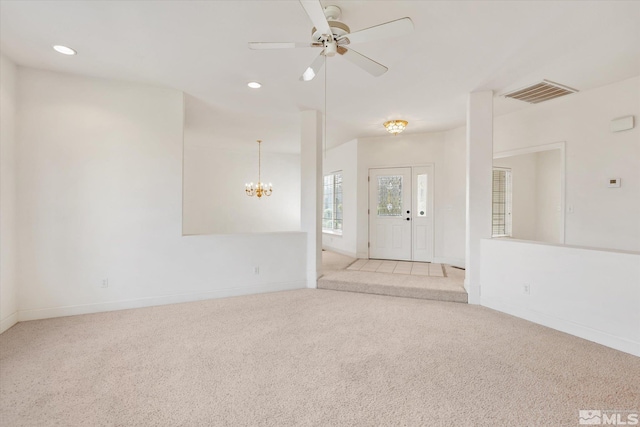 interior space featuring ceiling fan with notable chandelier and light colored carpet