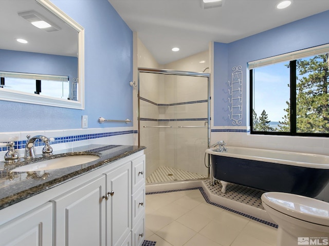 full bathroom with a healthy amount of sunlight, separate shower and tub, vanity, and toilet