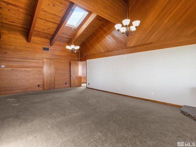 spare room with high vaulted ceiling, beamed ceiling, an inviting chandelier, a skylight, and wood walls