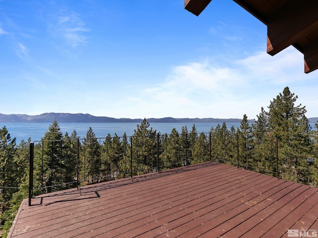 wooden deck with a water and mountain view