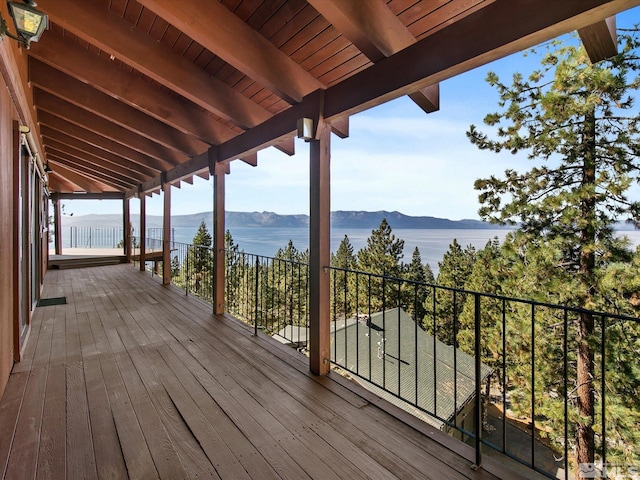 wooden terrace with a water and mountain view