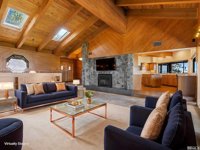 living room featuring wood ceiling, wood walls, beam ceiling, a stone fireplace, and high vaulted ceiling